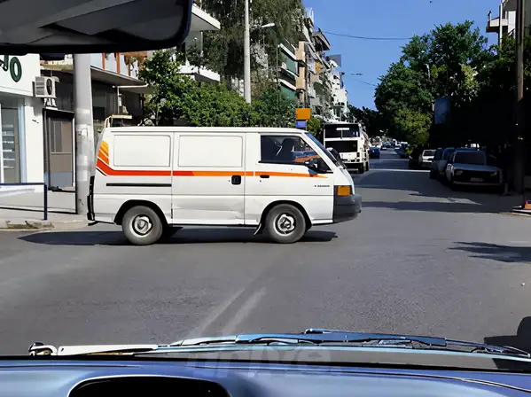 Εικόνα που συνοδεύει την ερώτηση: Προτίθεσθε να κινηθείτε ευθεία, αλλά το λευκό αυτοκίνητο έχει σταματήσει σε κακή θέση περιμένοντας να διασχίσει το οδόστρωμα και έχει κλείσει ένα μέρος της λωρίδας κυκλοφορίας σας. Πώς θα ενεργήσετε: